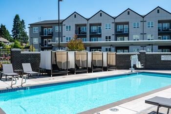 a swimming pool with an apartment building in the background